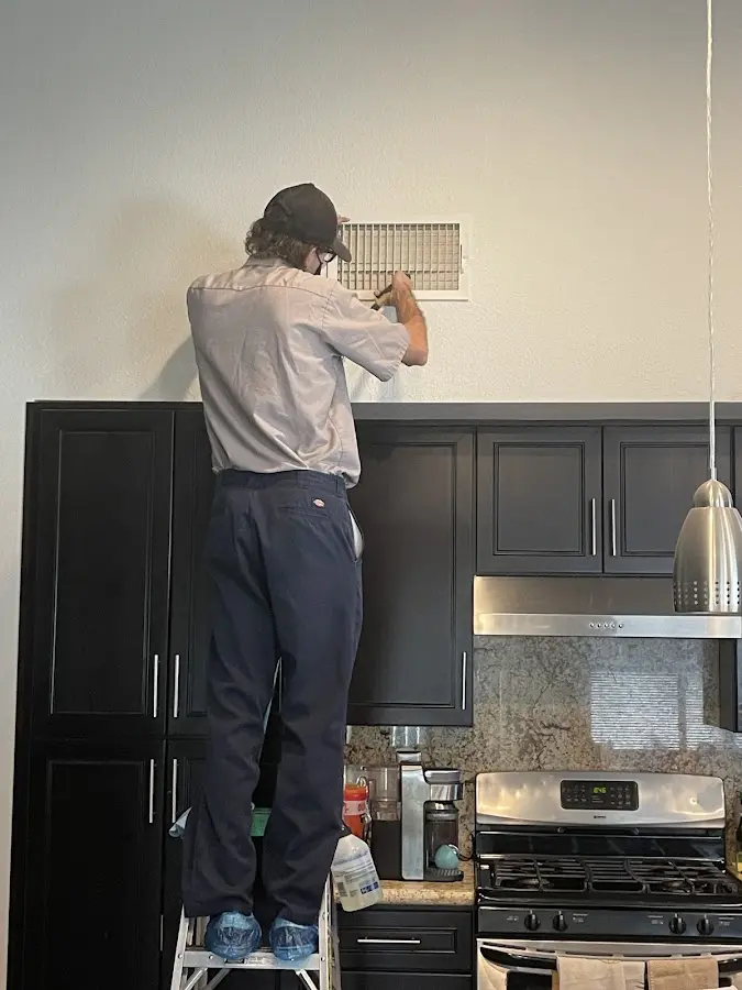 Technician inspecting an air vent during HVAC service in River Ridge